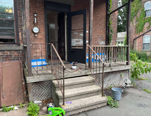 Porch before renovation with worn paint and steps