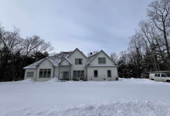 Professional roof snow removal - wide view of residential home